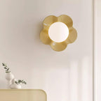 A small vase of greenery sits on the cabinet below this Clérachic wall light in yellow.