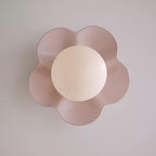 Photographed head-on, this Clérachic wall light in pink sits unlit against a plain grey backdrop.