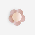 Close studio shot of this Clérachic wall light in pink, its ball tinted warm against a white backdrop.