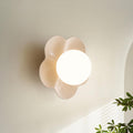 Near an archway with a plant in the corner, this Clérachic wall light in white glows softly.