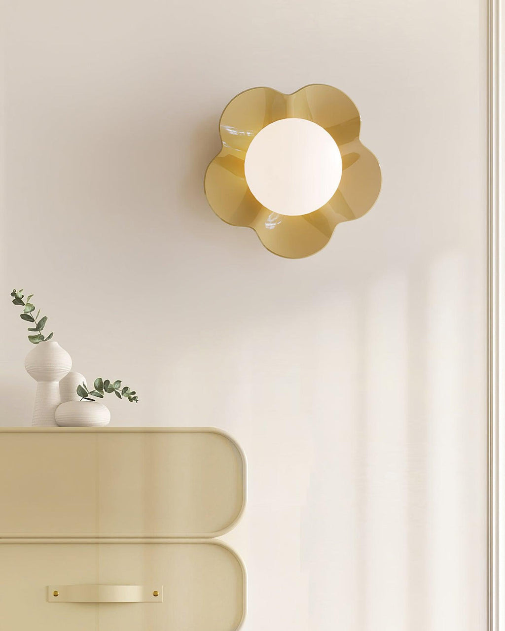 Above a cabinet holding a small vase, this Clérachic wall light in yellow glows softly on the wall.