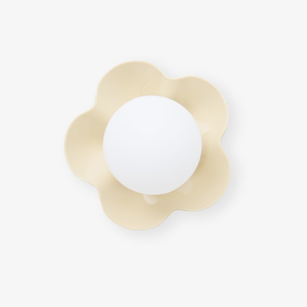 Seen straight on, this Clérachic wall light in a pale cream finish sits unlit against a white backdrop.