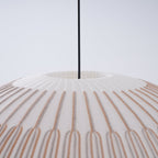 Clérachic knit pendant lamp in macro at the crown, the ribs radiating from the small opening where the cord enters the shade.