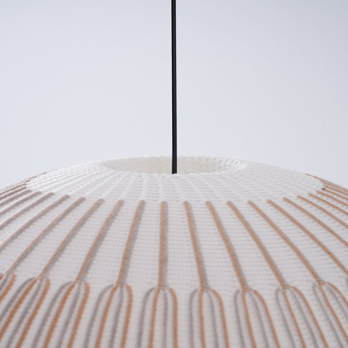 Clérachic knit pendant lamp in macro at the crown, the ribs radiating from the small opening where the cord enters the shade.