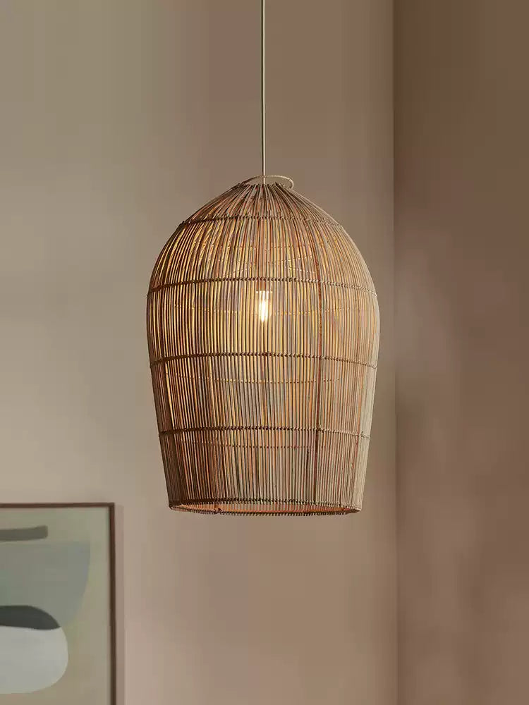 This Clérachic pendant hangs against a plain wall, the edge of an abstract framed print visible below.