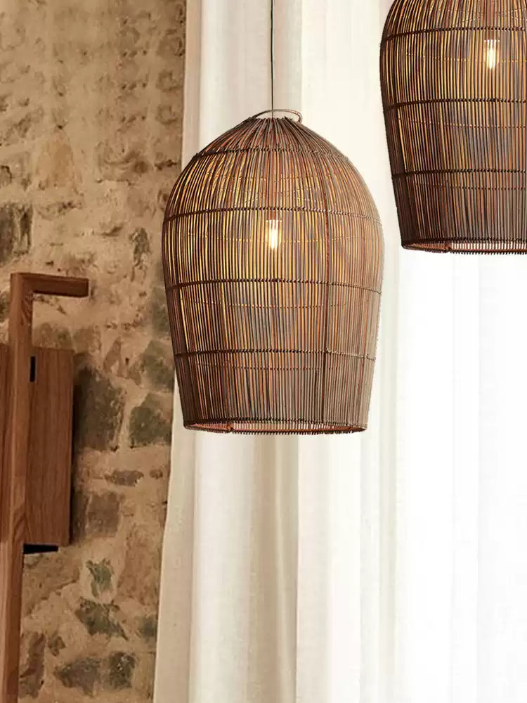 Against a stone wall and sheer curtain, this Clérachic pendant hangs near a wall sconce and a second pendant beyond.
