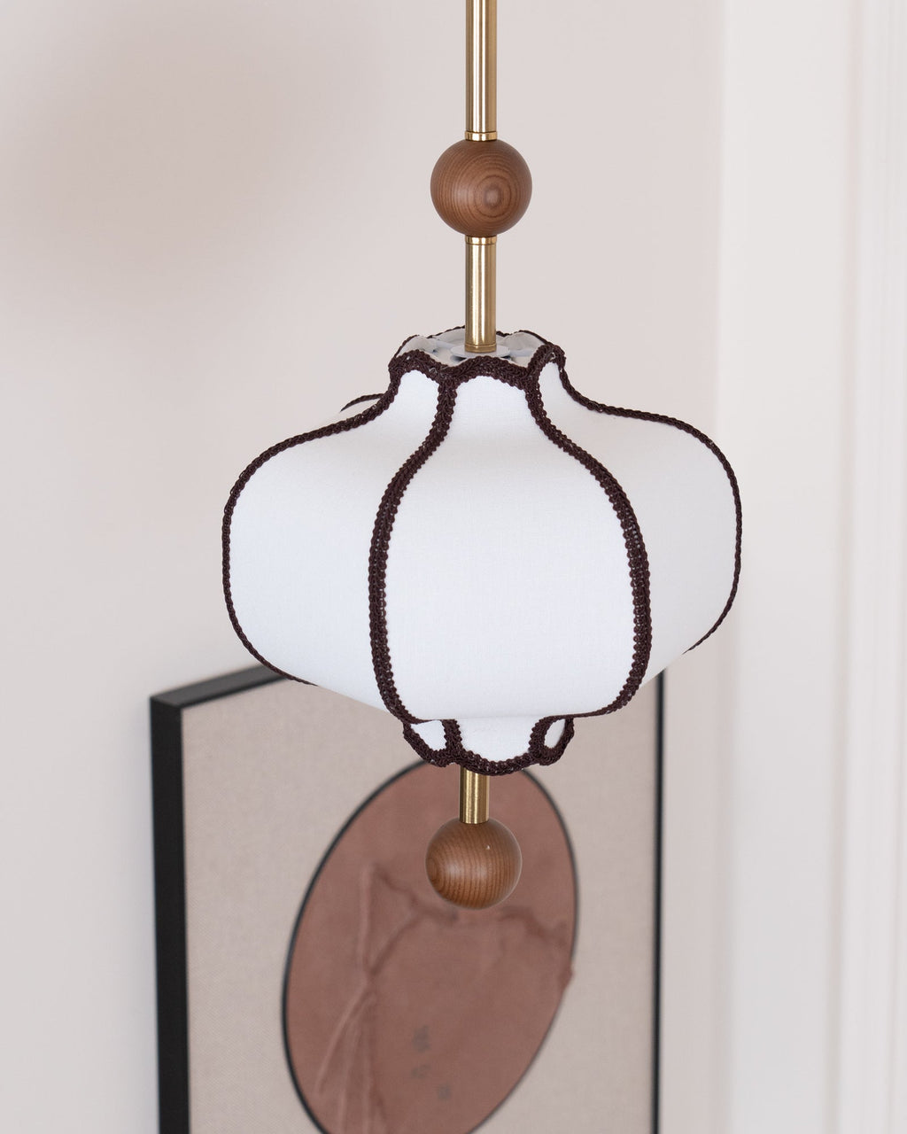 Lantern pendant light glowing warmly over a bedside table