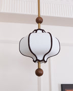 White fabric pendant light with gold frame and warm bulb