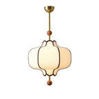 White fabric lantern pendant light hanging over a dining table