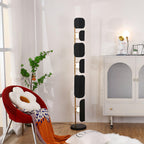 A tighter crop of the same corner, the Clérachic floor lamp's glass panels glowing beside the arched cabinet and potted plant.