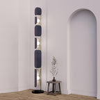 Near an archway, the Clérachic floor lamp glows beside a small wood stool holding a dried branch stem.