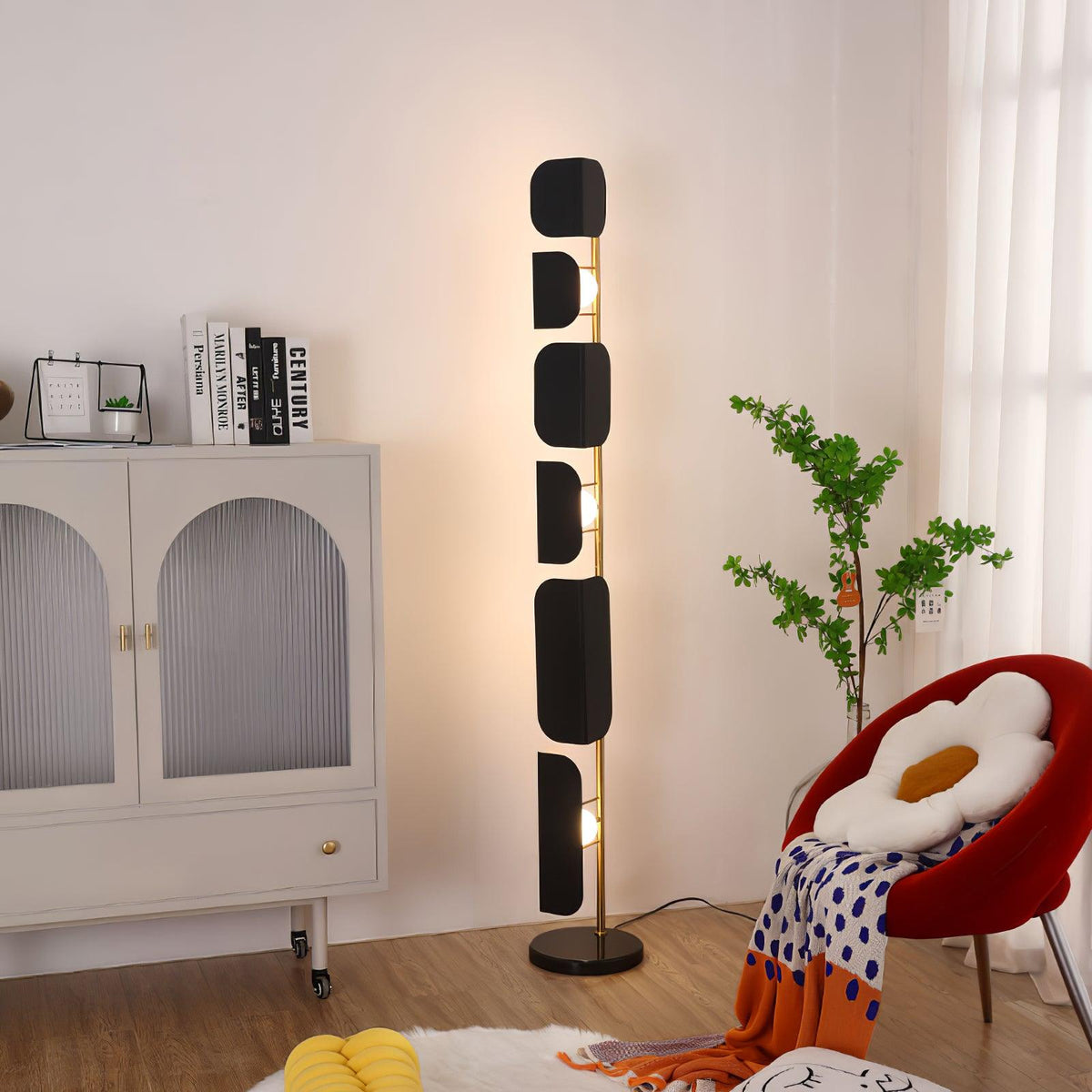 The same Clérachic corner setting shown from a wider angle, the black glass panels lit beside the cream arched cabinet.