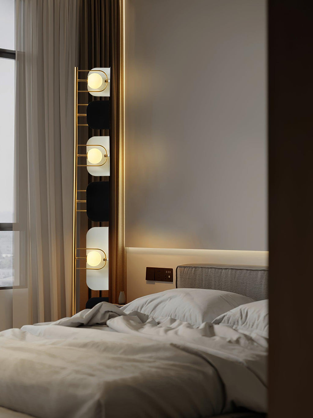 A close crop inside the bedroom shows the Clérachic floor lamp's top panels glowing above a made-up bed.