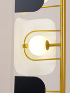 Macro detail of one lit opal glass globe seated in the Clérachic floor lamp's gold frame beside a black glass panel.