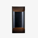 Solid brass wall sconce casting a warm glow on a hallway