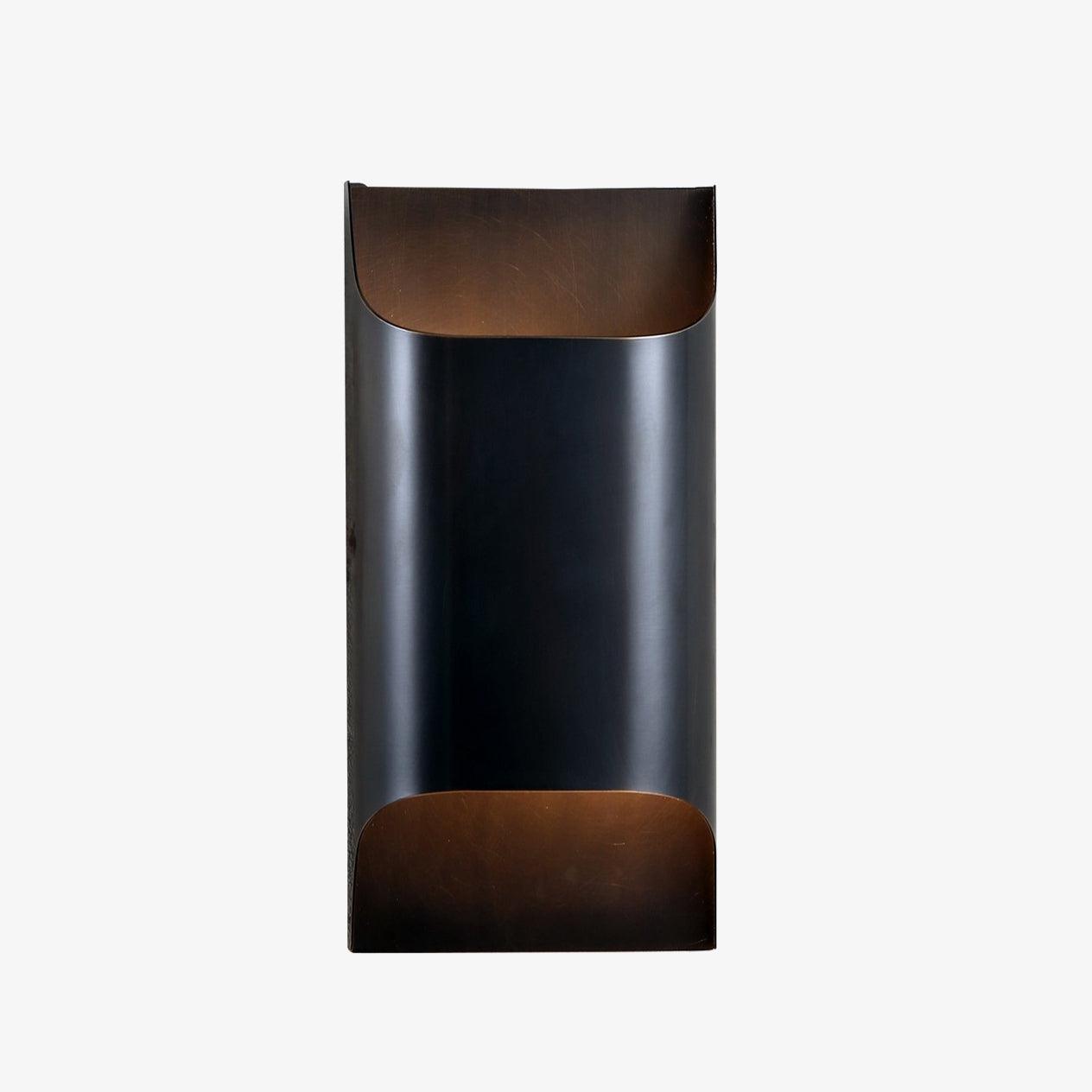 Solid brass wall sconce casting a warm glow on a hallway