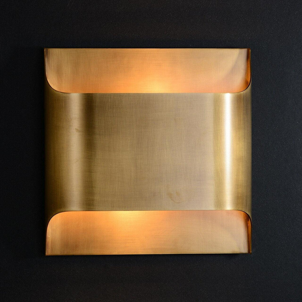 Matte black wall sconce with warm bulb on a plain wall