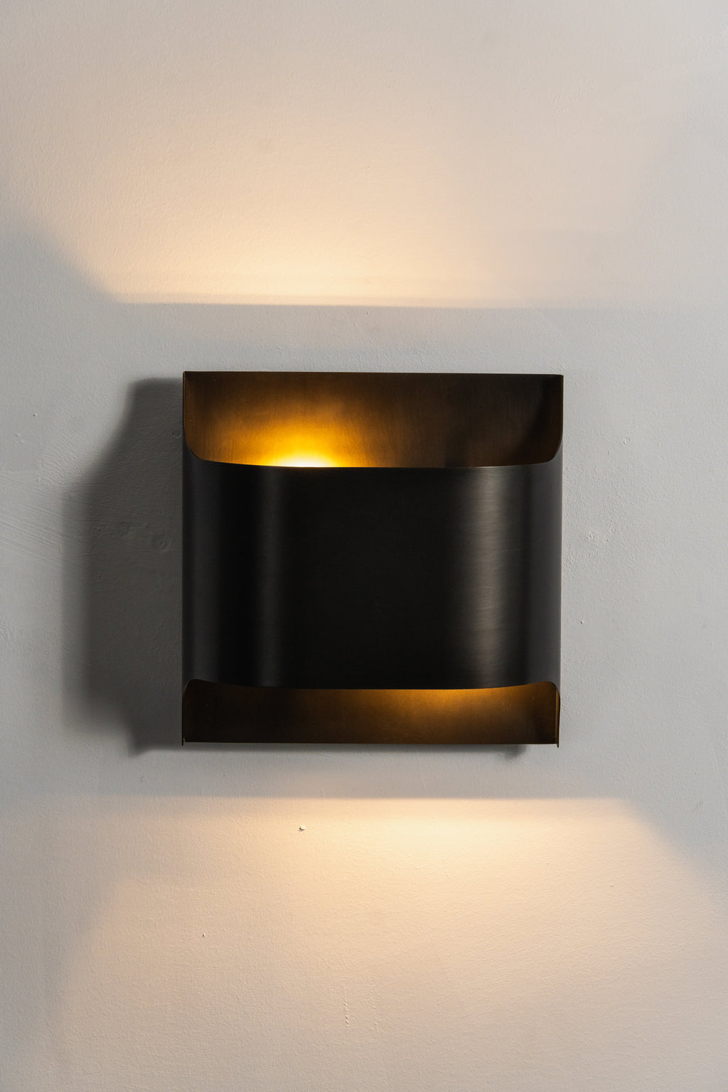 Brass wall sconce shown close up with polished finish