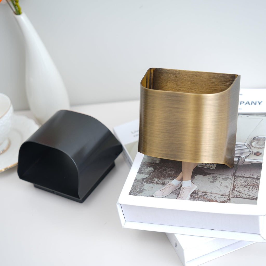 Brass wall sconce glowing warmly against a textured wall