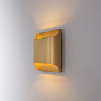 Polished brass wall sconce with rounded globe and warm bulb
