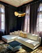 Curved disc pendant light casting soft light in a lounge