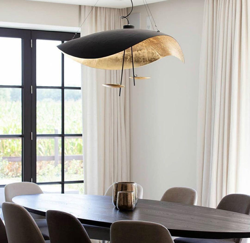 Curved disc pendant light glowing above a seating area
