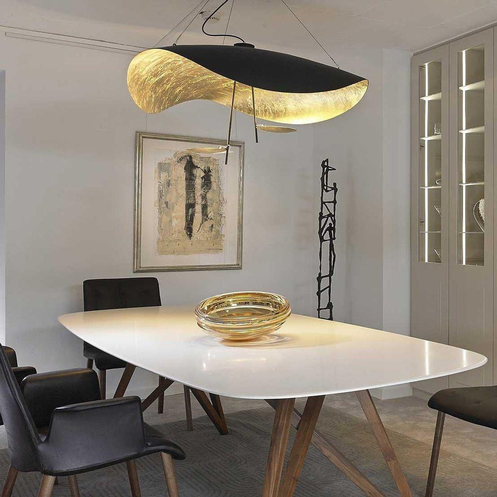 White and gold disc pendant light against a dark backdrop