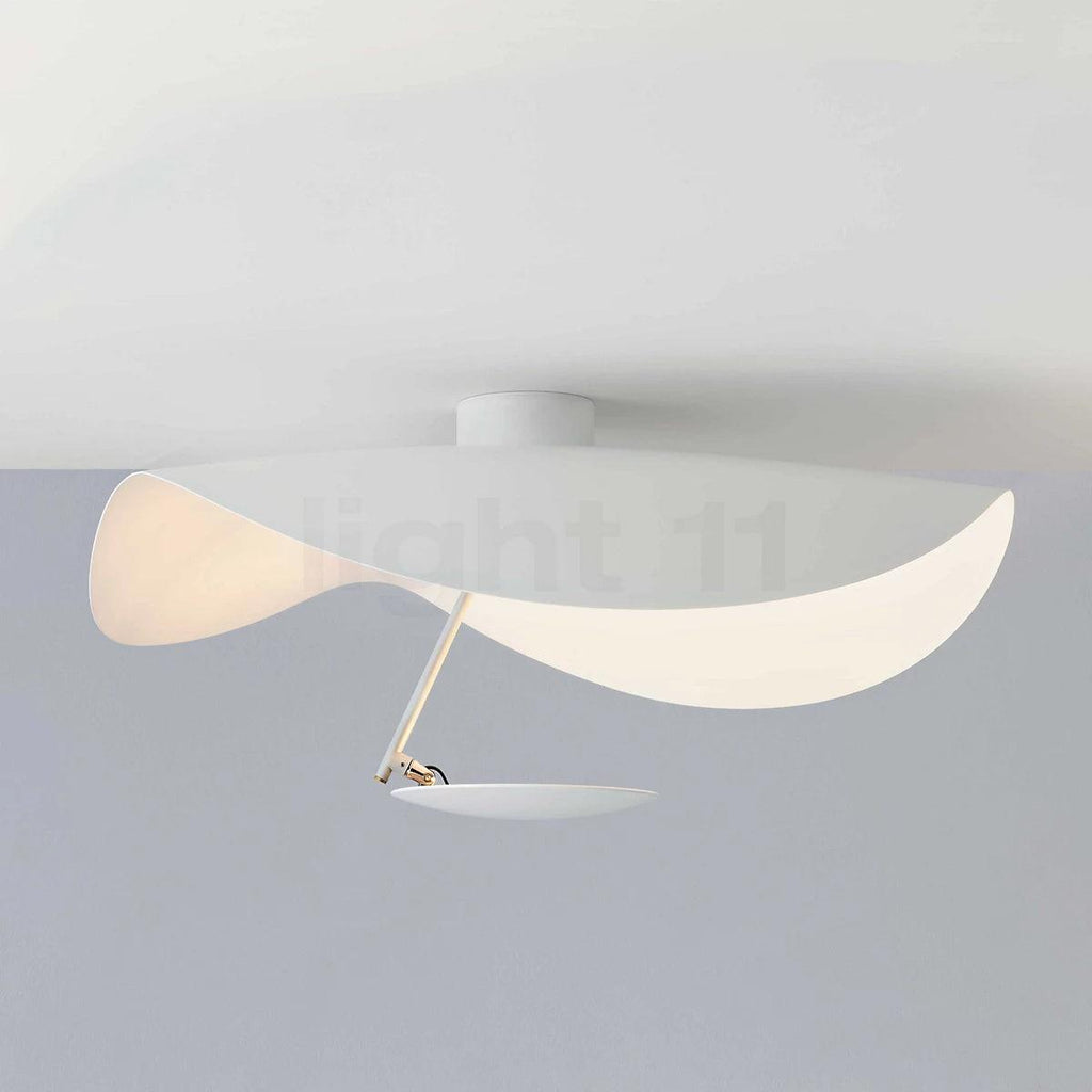 Curved steel disc ceiling light glowing above a room