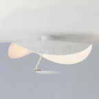 Curved steel disc ceiling light glowing above a room