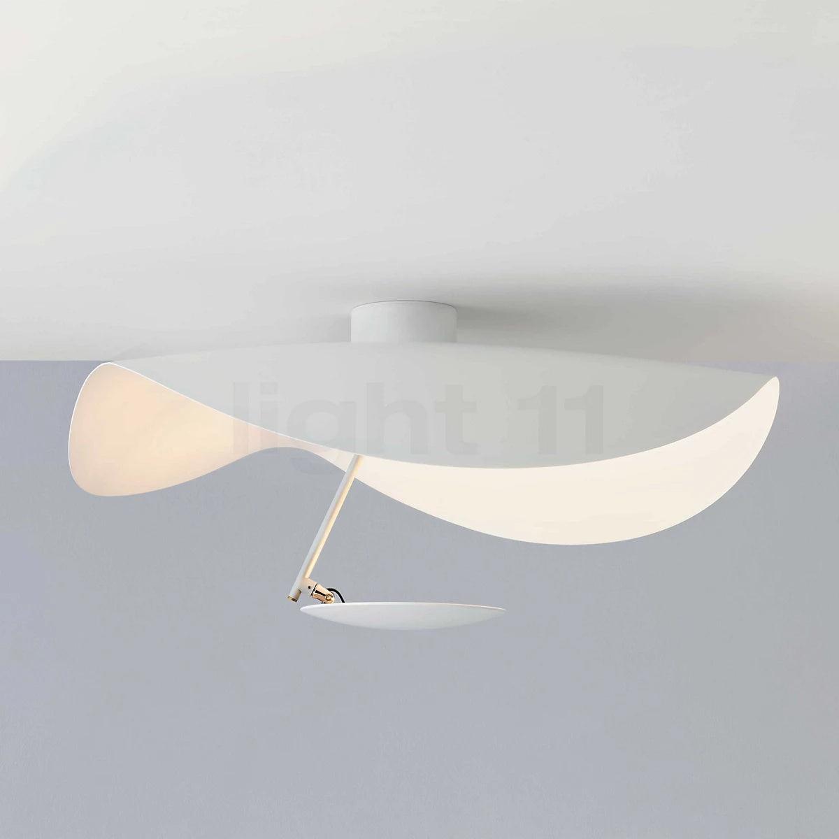 Curved steel disc ceiling light glowing above a room