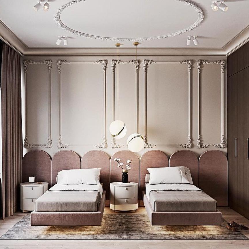 Between two beds on a dusky pink panelled wall, a single opal pendant glows, from Clérachic.