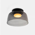 Stacked glass-disc ceiling light glowing soft warm light in a hallway