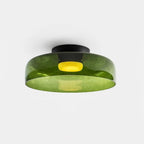 Smoke grey glass ceiling light glowing warm in a bedroom