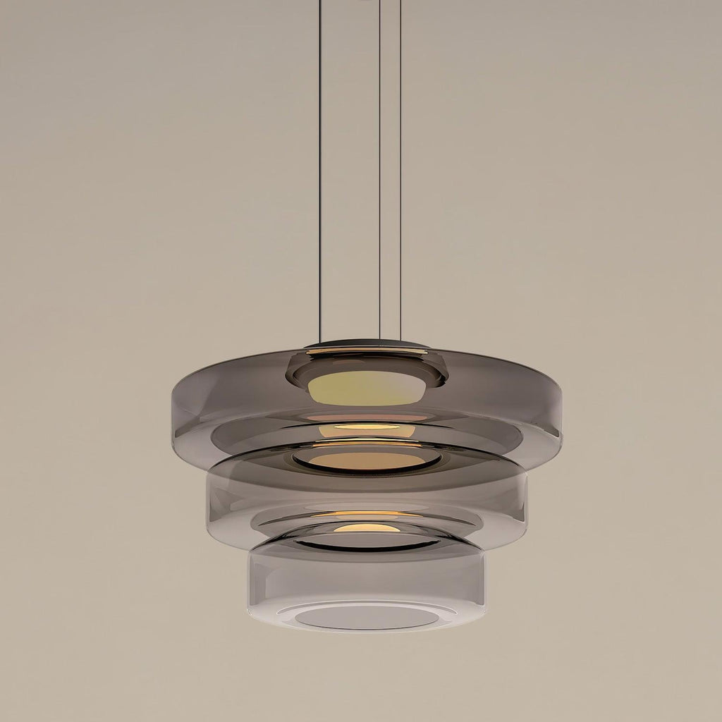 Amber-toned mouth-blown glass pendant light glowing softly indoors