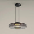 Layered mouth-blown glass pendant light glowing warm above a quiet interior