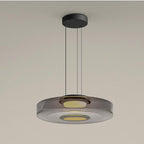 Layered mouth-blown glass pendant light glowing warm above a quiet interior