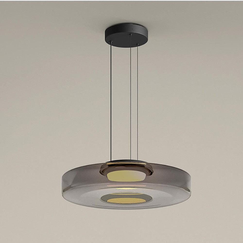 Layered mouth-blown glass pendant light glowing warm above a quiet interior