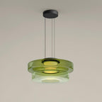 Tinted glass pendant light casting warm dimmable light over a table