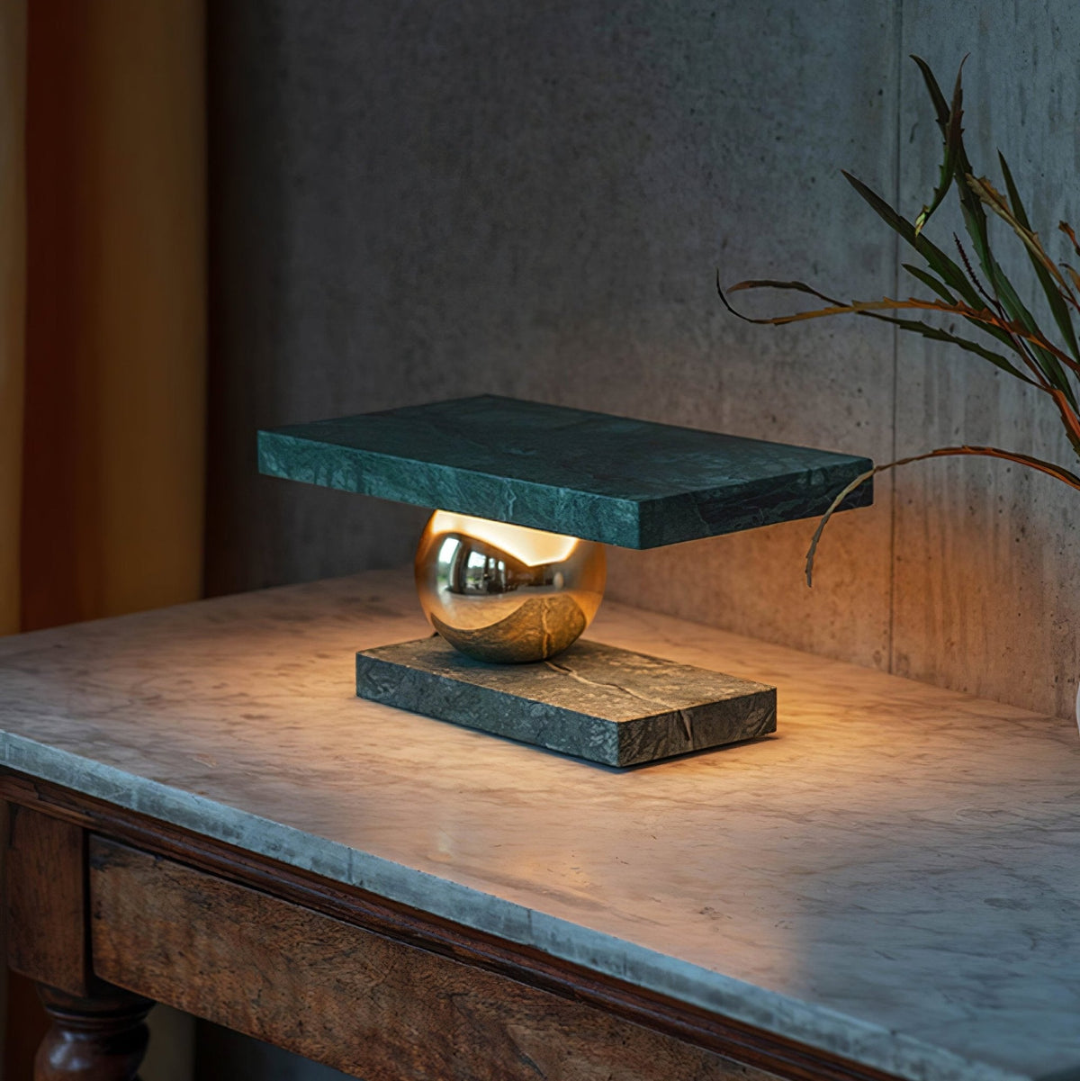 Near a sheer curtain, the Clérachic green marble lamp glows on its marble-topped console table.