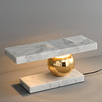 A tight three-quarter view catches the Clérachic white marble lamp glowing against a grey studio backdrop.