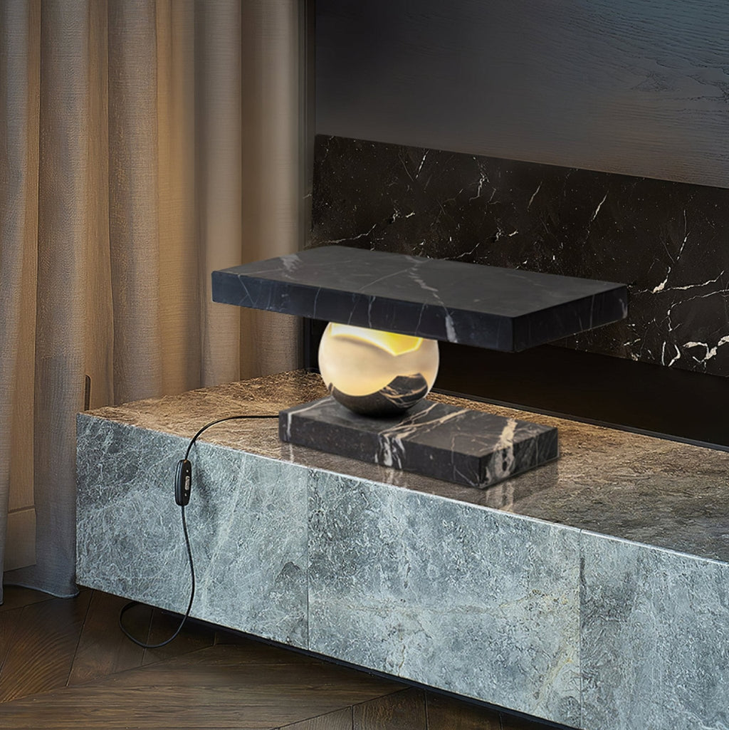 Clérachic black marble table lamp glowing on a stone-clad console beside a curtained fireplace, its cord plugged in.