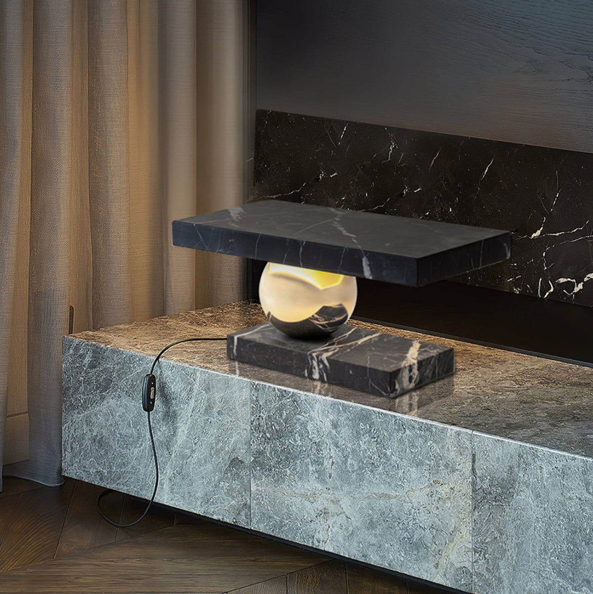 Clérachic black marble table lamp glowing on a stone-clad console beside a curtained fireplace, its cord plugged in.