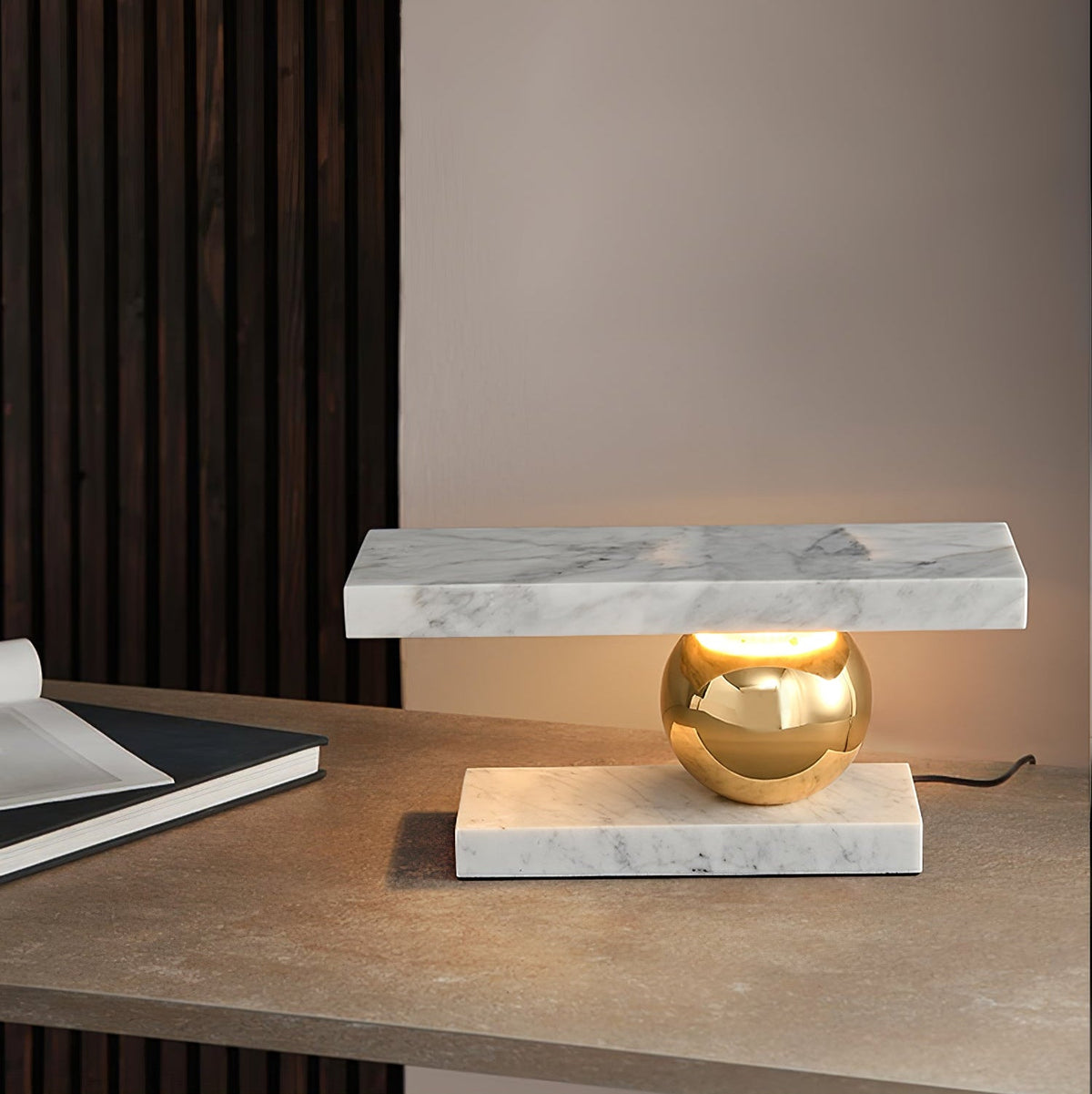 A notebook sits on the wooden desk beside the Clérachic white marble lamp, a wood-slat wall behind it.