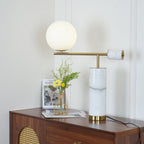 The Clérachic lamp's brass disc cap faces forward here, warm light spreading across the panelled wall behind the dresser.
