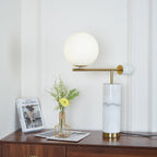 Cropped tighter on the same dresser scene, the Clérachic lamp's brass disc cap faces the camera beside its glass globe.