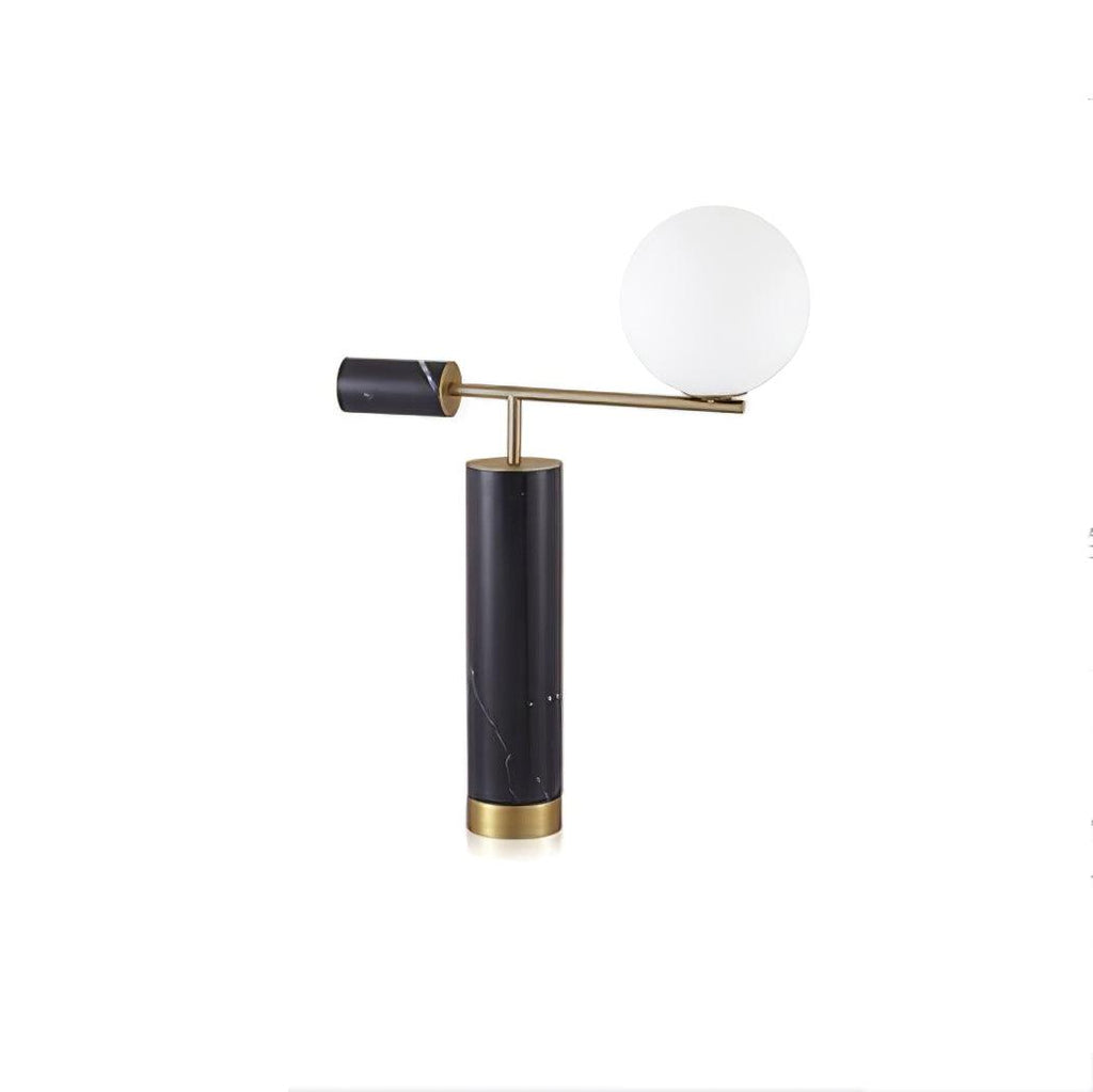 Set further from the camera, the Clérachic gold table lamp appears smaller within a plain white studio frame.