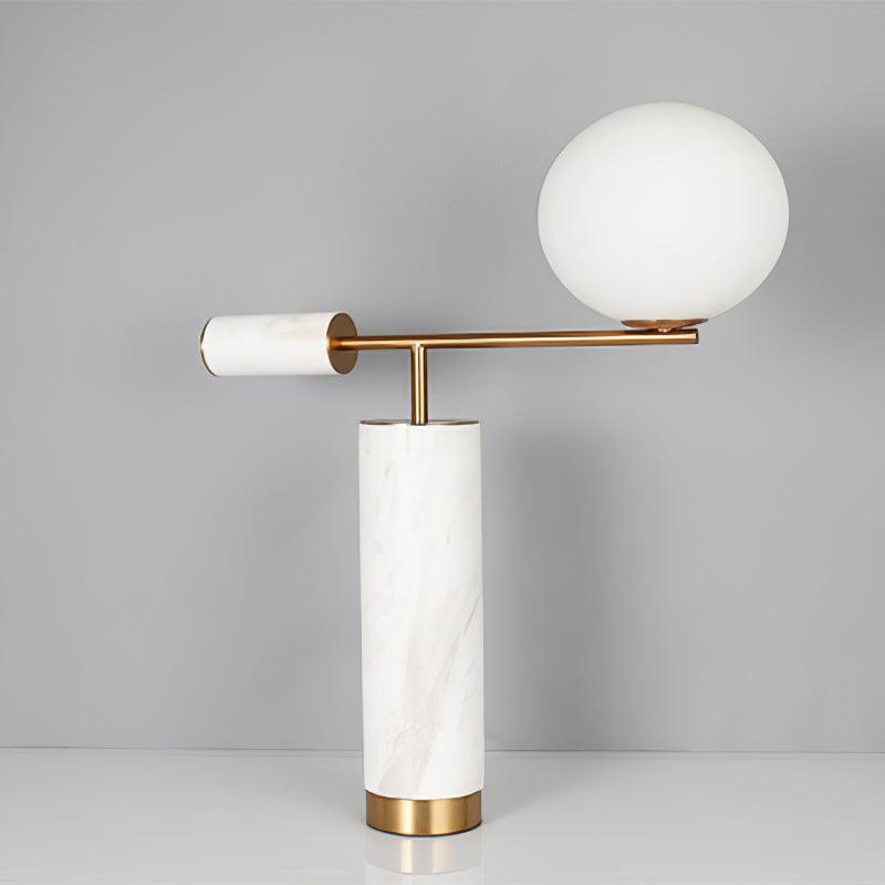 The same white marble Clérachic lamp and stacked books, now framed with the marble finial to the left of the globe.