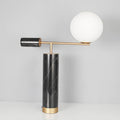 A plain white studio shot of the Clérachic lamp's black marble column, showing pronounced grey-white veining up close.