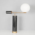 A plain white studio shot of the Clérachic lamp's black marble column, showing pronounced grey-white veining up close.