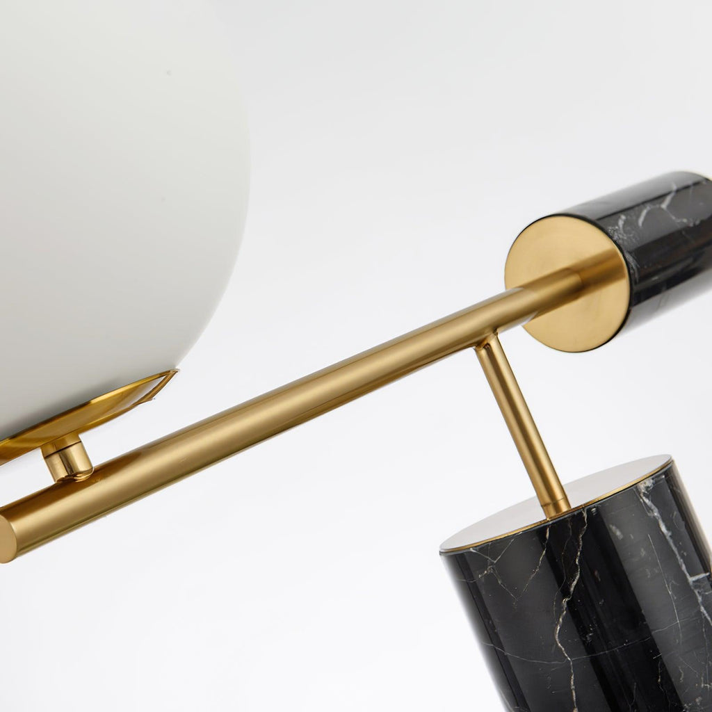 Shot along the diagonal arm, the Clérachic lamp's marble finial is sharp while its glass globe blurs softly behind it.